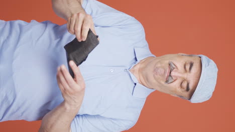 Vertical-video-of-Penniless-old-man-looking-at-his-empty-wallet.